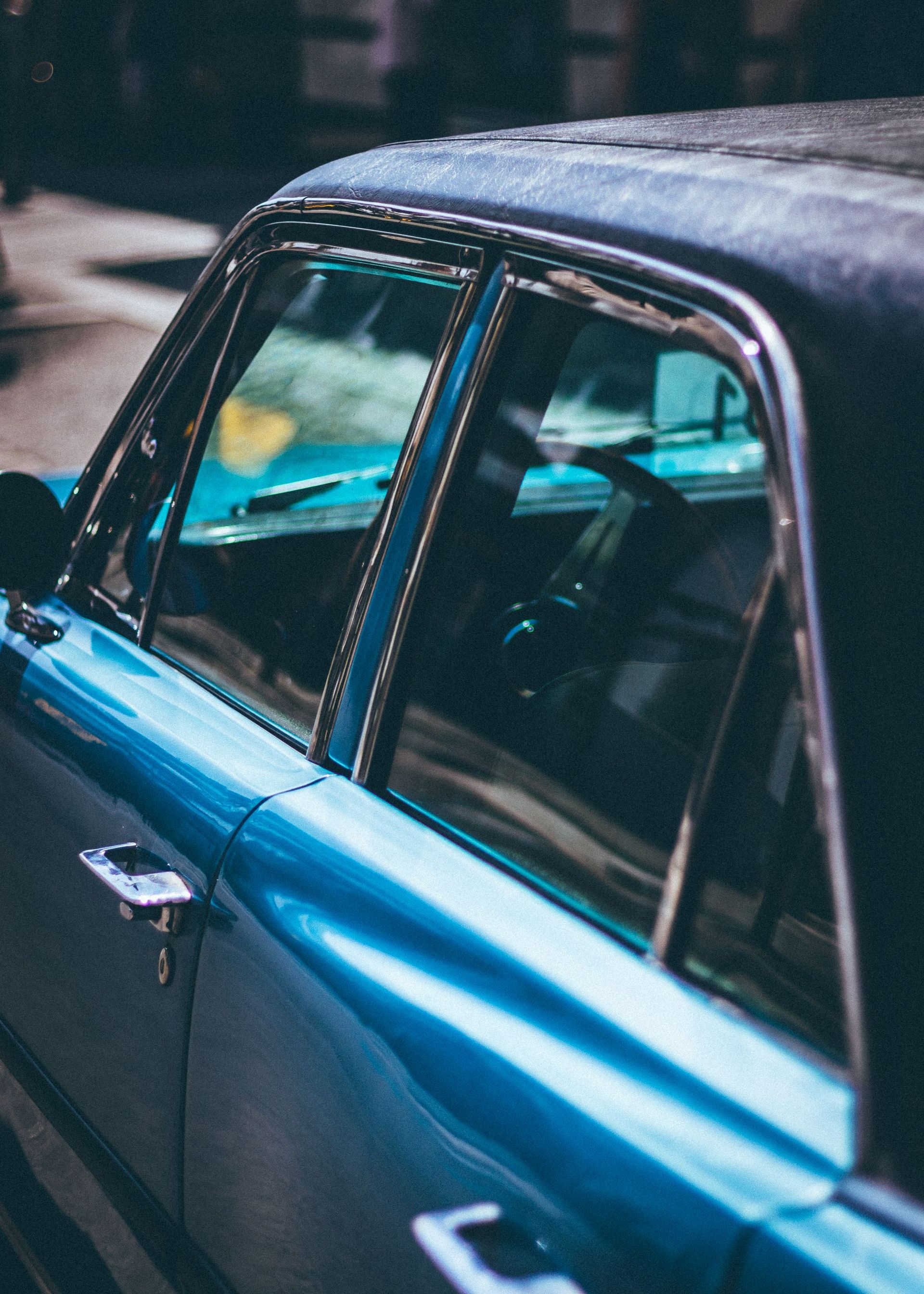 Detailed side view of a vintage blue car in Barcelona, Spain, capturing its classic design.